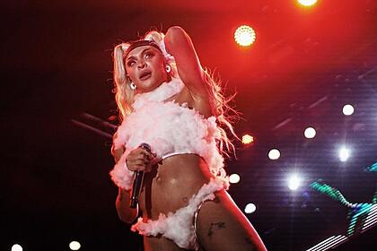 Pabllo Vittar com top branco e calcinha com plumas branca durante show em recife