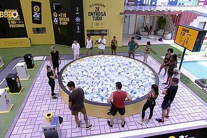 Participantes do Big Brother Brasil em volta de uma piscina de cubo na área externa da casa