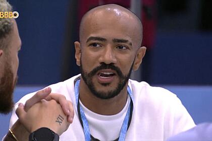 Ricardo sentado olhando para Fred com a boca aberta