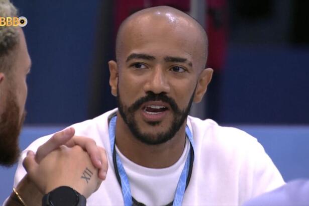 Ricardo sentado olhando para Fred com a boca aberta