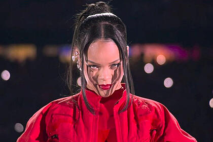 Rihanna de sobretudo e calça vermelha durante apresentação no Super Bowl