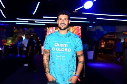 Rodrigo Mussi sorrindo, com a mão no bolso, camisa azul durante passagem num camarote
