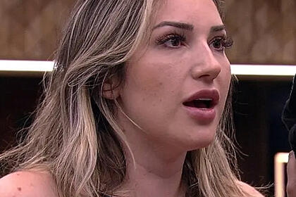 Amanda com o dedo pra frente, boca aberta, cabelo banhado