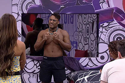 Fred Nicácio em pé na Casa do Reencontro do BBB 23 conversando, com Key e Gustavo de frente para ele de costas para a imagem