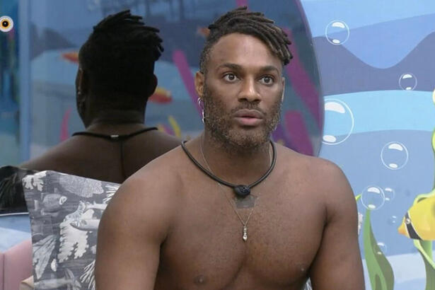 Fred Nicácio sem camisa, sentado uma das camas no quarto fundo do mar