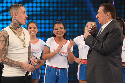 Mc daniel no palco do programa raul gil, ao lado do apresentador