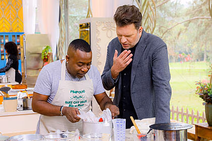 Pimpolho e carlos bertolazzi em frente a bancada, no episódio de estreia do bake off celebridades
