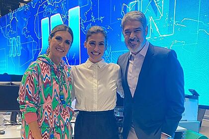 Fátima Bernardes abraçada com Renata Vasconcellos e William Bonner no cenário do Jornal Nacional