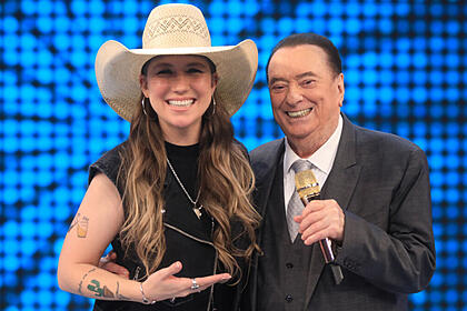 Bruna viola no palco do programa raul gil, ao lado do apresentador