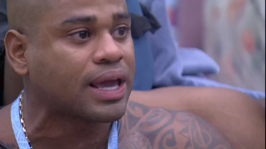Cezar Black chorando no Quarto Fundo do Mar, sem camisa, com colar azul no pescoço