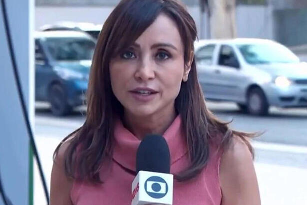 Elaine Bast em trecho de uma reportagem na rua, com o microfone da Globo em mãos