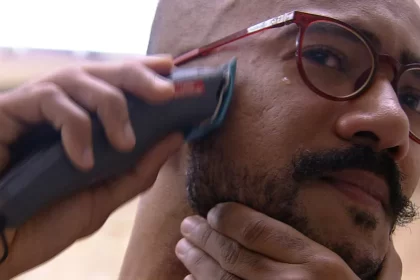 Ricardo com uma máquina de barbear, de óculos de grau, no banheiro do BBB 23