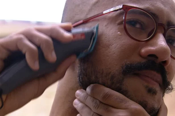 Ricardo com uma máquina de barbear, de óculos de grau, no banheiro do BBB 23