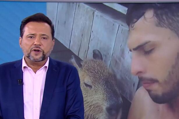 Geraldo Luís apresentando o Balanço Geral SP ao lado do telão que mostra imagens da Capivara Filó e seu tutor Agenor Tupinambá