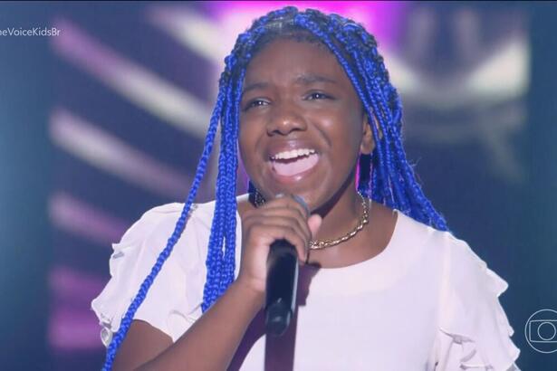 Isaraelly Bonfim segura o microfone e canta no palco do The Voice Kids 8