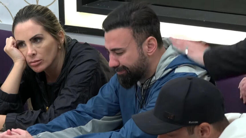 Bruno Tálamo chorando sentado na mesa de A Grande Conquista e sendo consolado por colegas