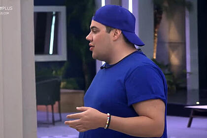 Erick de camisa e chapéu azul conversando em A Grande Conquista