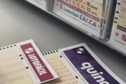 Mão anota número no bilhete da Lotofácil e Quina