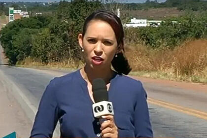 Apresentadora Leilane Macedo Lustosa segurando o microfone da TV Anhanguera, afiliada da Globo no Tocantins