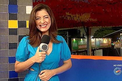 Meiry Lanunce segura o microfone da Record enquanto apresenta o Jornal Guararapes