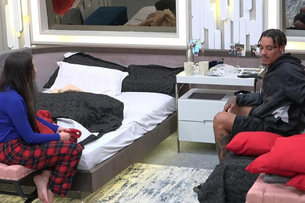 Victoria Macan e Murilo Dias sentados nas camas e discutindo no quarto dos Donos no A Grande Conquista