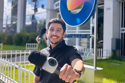 Anderson Souza segura o microfone da Record TV em frente a sede da TV Guararapes em Recife, Pernambuco
