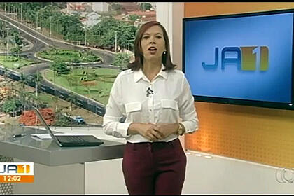 Apresentadora que sofreu o acidente, Leilane Lustosa, Macedo apresentando o JA1 na TV Anhanguera.