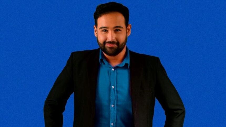 Pablo Marques de terno preto e camisa azul sorrindo em foto de lançamento do podcast do venenoso na TV Guararapes