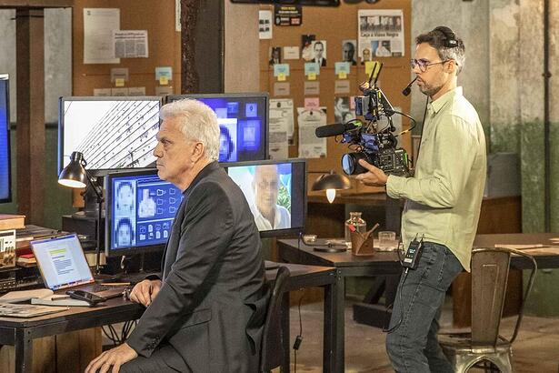 Pedro Bial no cenário do Linha Direta olhando para o computador