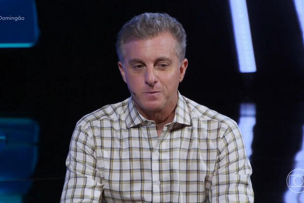 Luciano Huck sentado no estúdio do quadro The Wall