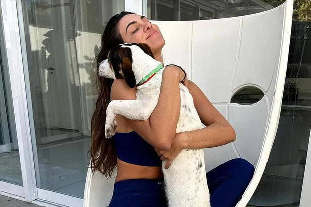 Pétala Barreiros abraçada com o cachorro resgatado