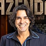 André Gonçalves de camisa social azul escura e sorrindo para divulgação de A Fazenda
