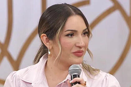 Amanda Meirelles setada no sofá, em trecho de participação do Encontro