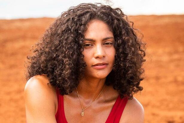 Barbara Reis de regata vermelha, colar de brilhante, cabelo solto, caracterizada como Aline, durante gravação de Terra e Paixão, da TV Globo