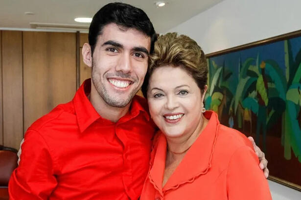 Jefferson Monteiro e Dilma Rousseff de camisa vermelha, sorrindo, abraçados