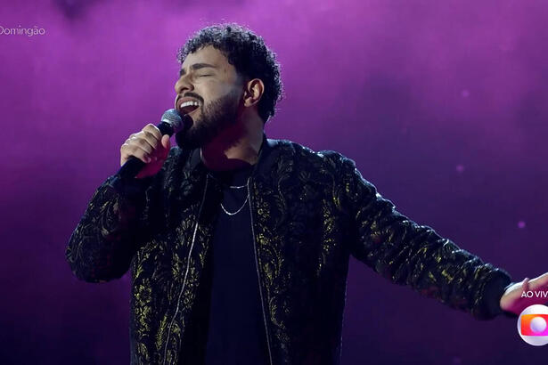 Gabriel Henrique cantando no palco do Domingão