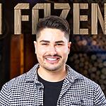 Lucas Souza de camisa preta lisa e uma camisa social cinza por cima, sorrindo na divulgação de A Fazenda 15