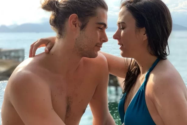 Tatá Werneck de biquini azul, com a mão no ombro de Rafael Vitti durante viagem
