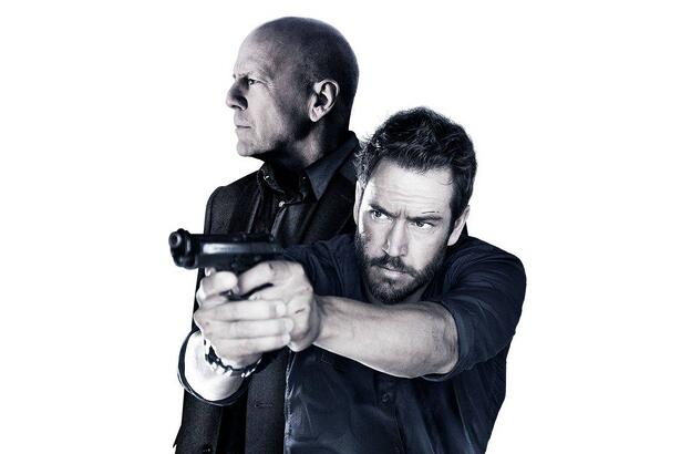 Bruce Willis por trás de Mark-Paul Gosselsaar que aponta uma arma em foto de divulgação do filme da Tela de Sucessos