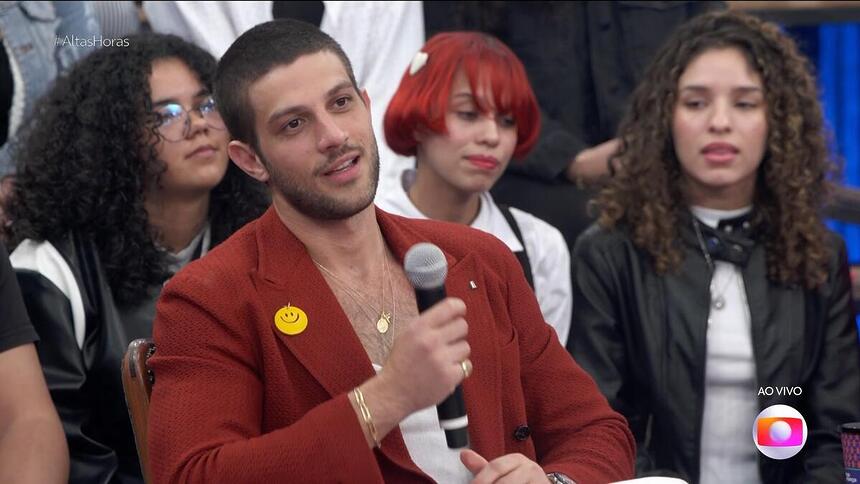 Chay Suede segura o microfone e sorrir antes de falar de Rebelde e da Record no Altas Horas