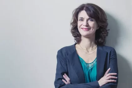 Autora de novelas Licia Manzo de terno azul e blusa verde