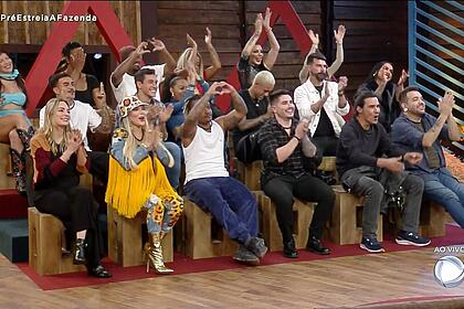 18 peões de A Fazenda 15 batendo palmas no deck, na final da pré-estreia do reality show