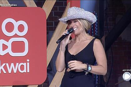 Adriane Galisteu ao lado do logo do Kwai que patrocina a festa de A Fazenda 15