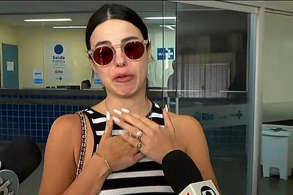 Sthefany Brito coloca a mão no peito enquanto chora na saída do hospital Miguel Couto onde o irmão Kayky Brito estava internado