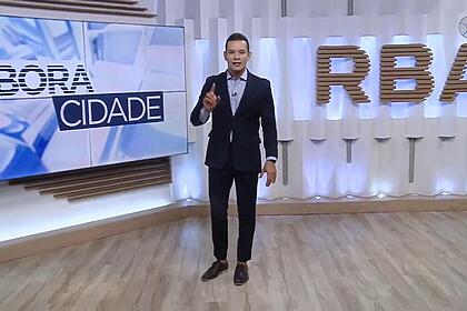 Agenor Santos levanta o dedo enquanto anda no estúdio do Bora Cidade, da RBATV, afiliada da Band