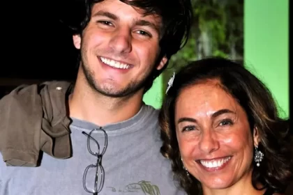 Cissa Guimarães sorrindo ao lado do filho, de camisa cinza que também está sorrindo