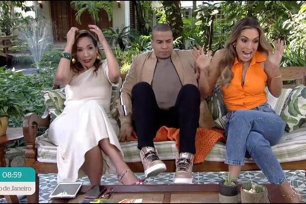 Maria Beltrão coloca a mão na cabeça, Thiago Oliveira levanta as pernas e Talitha Morete dá um grito quando um papagaio joga uma manga neles