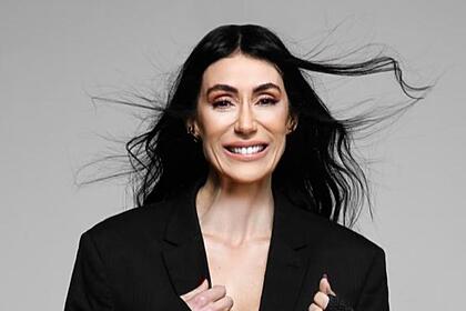 Michelle barros de terninho preto e cabelos ao vento em foto de divulgação do sbt