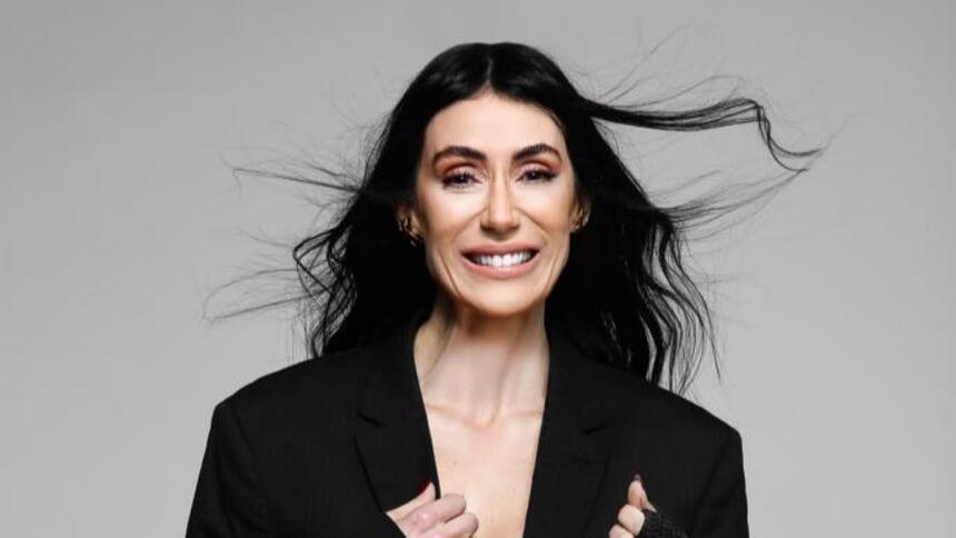 Michelle Barros de terninho preto e cabelos ao vento em foto de divulgação do SBT