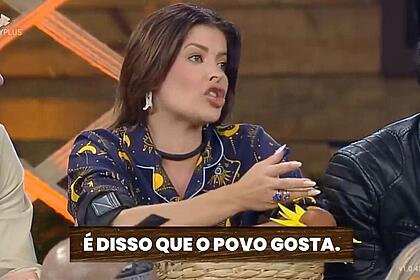 Jaquelline sentada segurando um vaso olhando para frente.